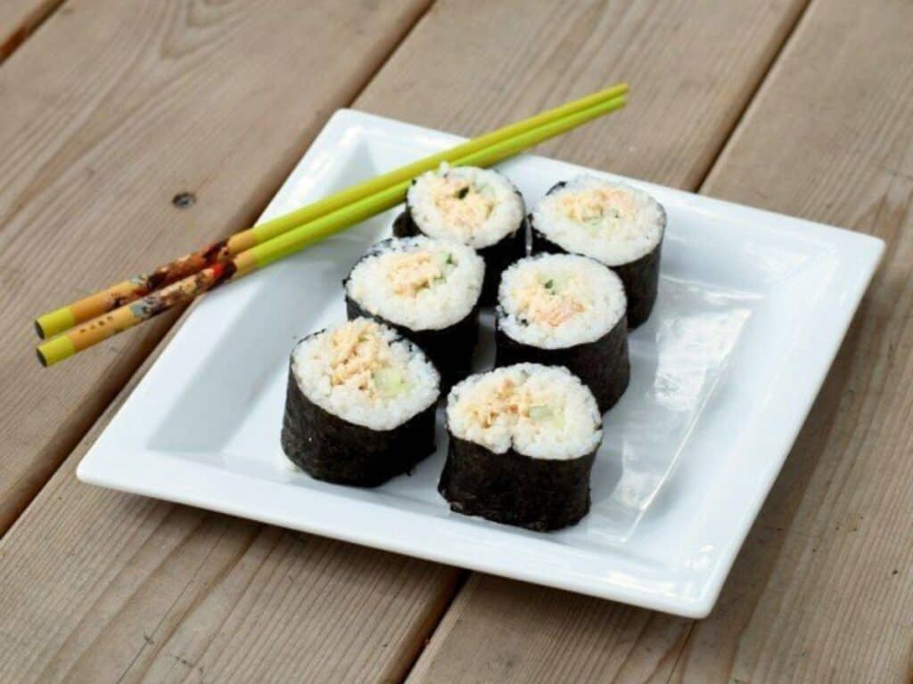 Image shows irresistible homemade spicy tuna rolls on a pate.