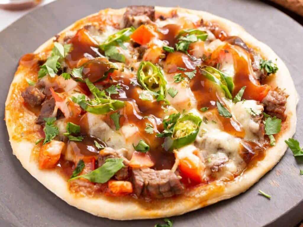 Image shows yummy Mexican steak pizza.