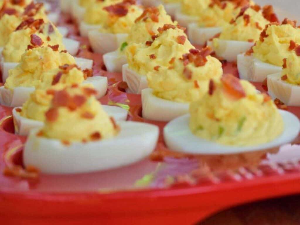 Image shows yummy bacon deviled eggs served on a platter.