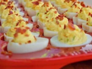 Image shows yummy bacon deviled eggs served on a platter.