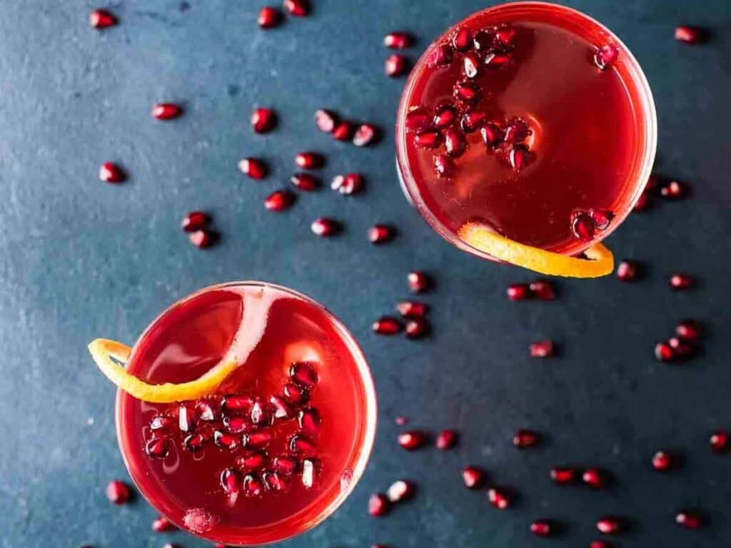 Image shows yummy champagne pomegranate cocktail.