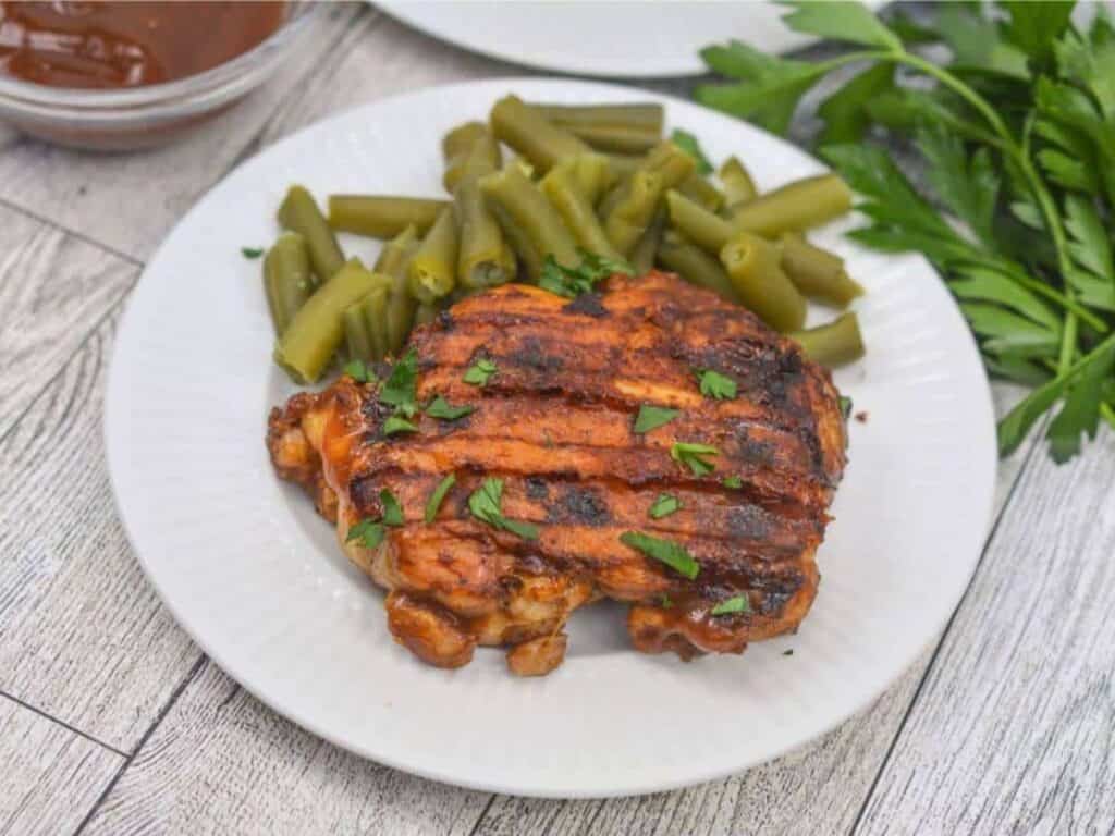 Image shows irresistible grilled bbq boneless chicken thighs.
