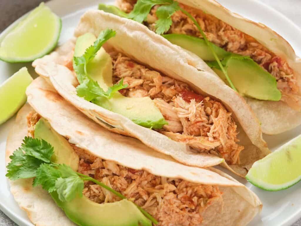 Image shows irresitible salsa chicken in slow cooker.