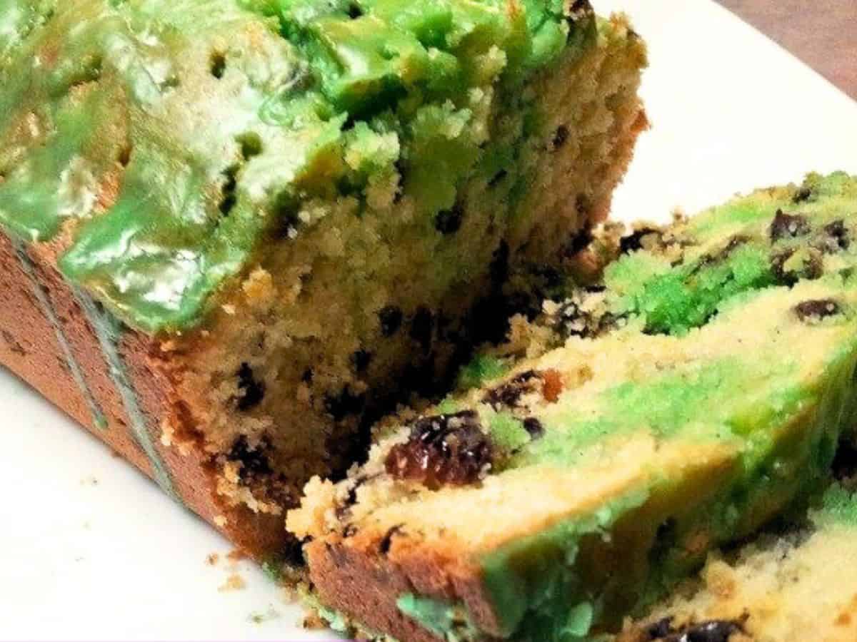 Image shows A slice of an Irish tea cake with green icing is on a plate.