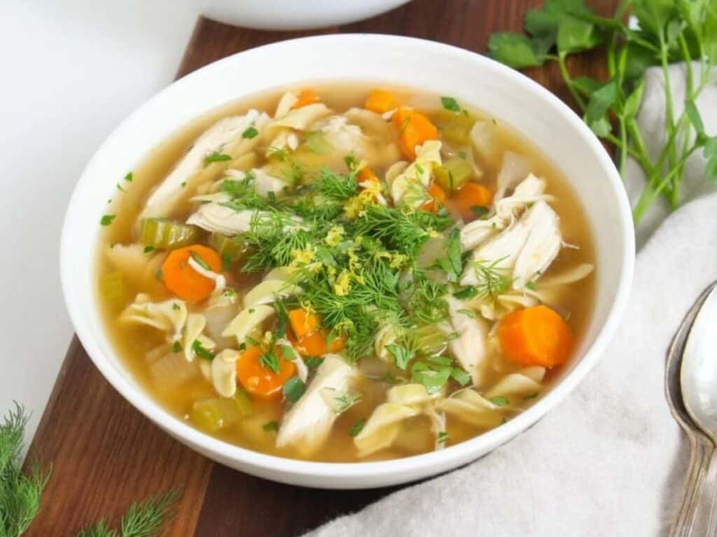 Image shows yummy crockpot chicken noodle soup.