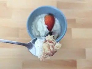 Image shows a spoonful of delicious strawberry mug cake.