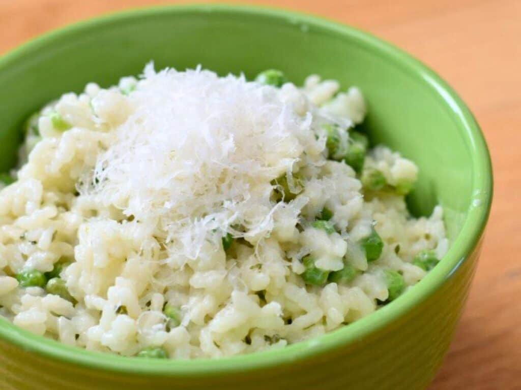 Image shows creamy and irresistible risotto with peas and lemon.