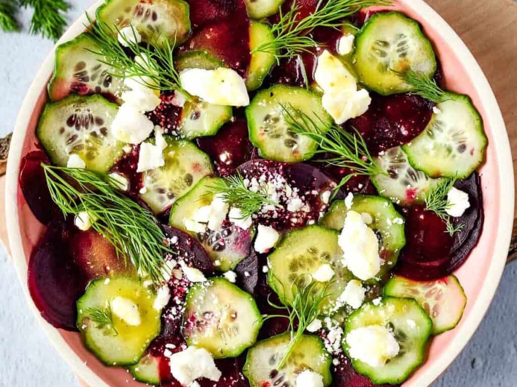 Image shows yummy beet cucumber salad with feta and dill.