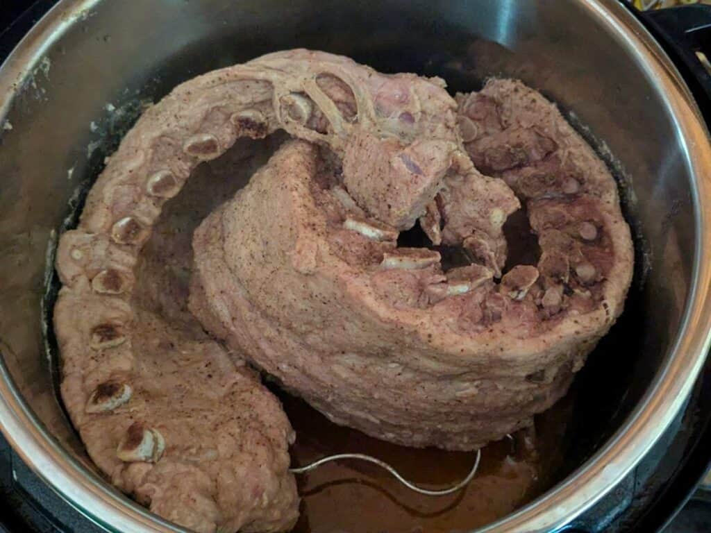 Image shows three pounds of cooked pork ribs ready to be transferred from the Instant Pot.