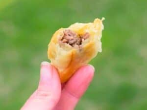 Image shows delicious puff pastry beef empanada.