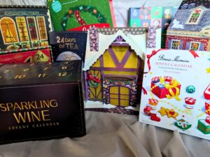 A collection of various advent calendars, including sparkling wine, tea, and Bonne Maman preserves.