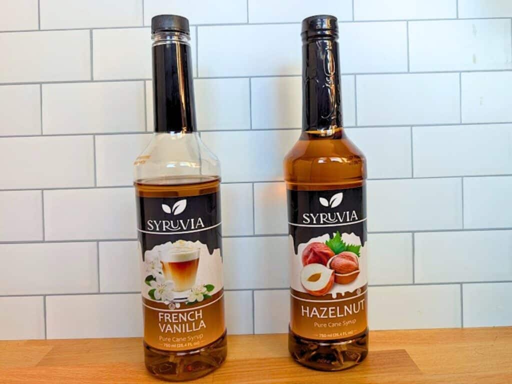 Two bottles of Syruvia pure cane syrup in French Vanilla and Hazelnut flavors.