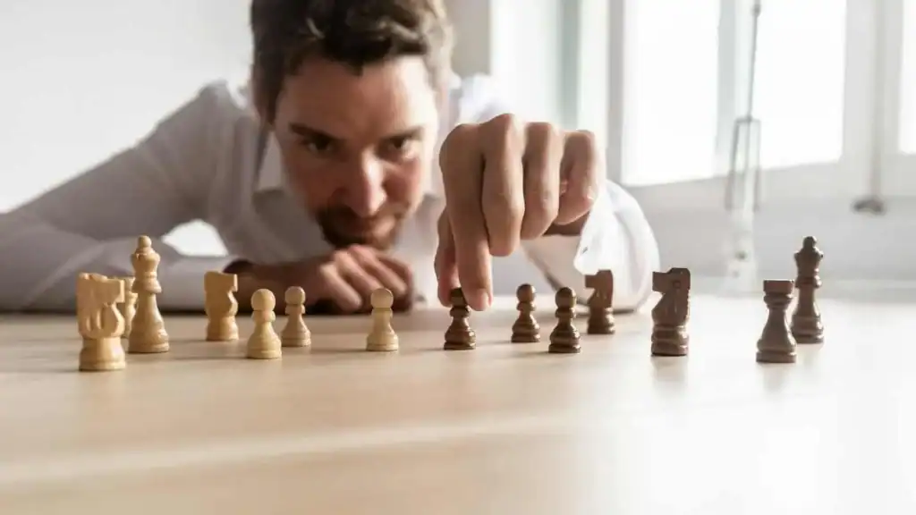 Kunstner spiller skakbræt i moderne kontormiljø, fokus på strategi og mentale færdigheder.