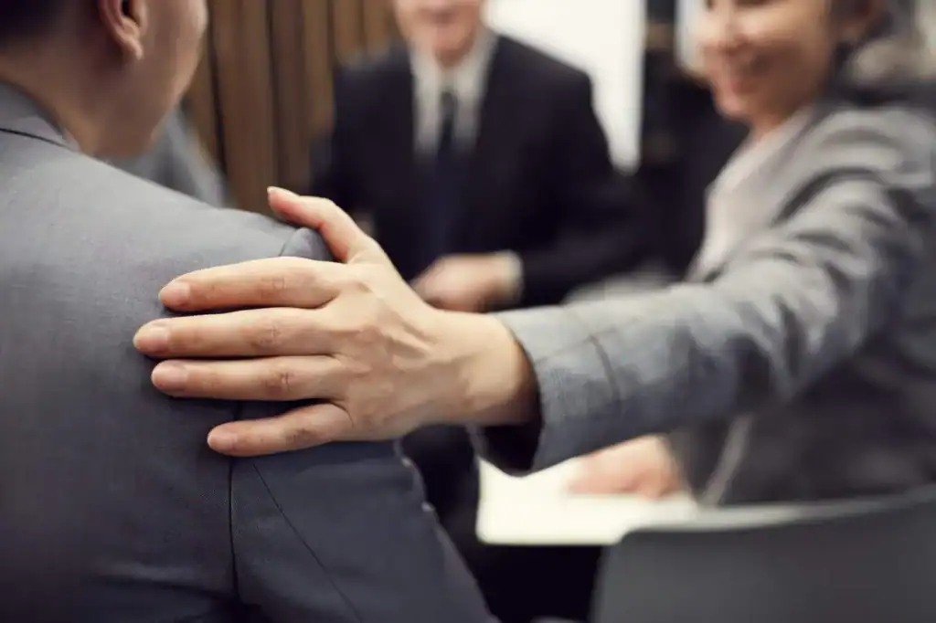 Berøring af kollega under teammøde, forretnings- og professionel kommunikation, HR og arbejdsplads.