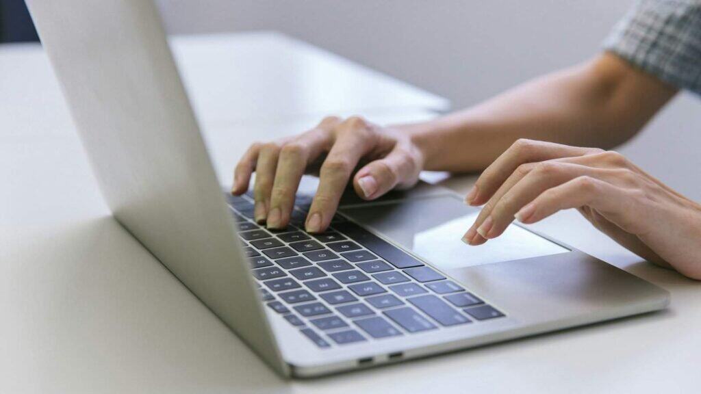 Hånd skrive på danmarksk kulturelle laptop computer for arbejde og teknologi.