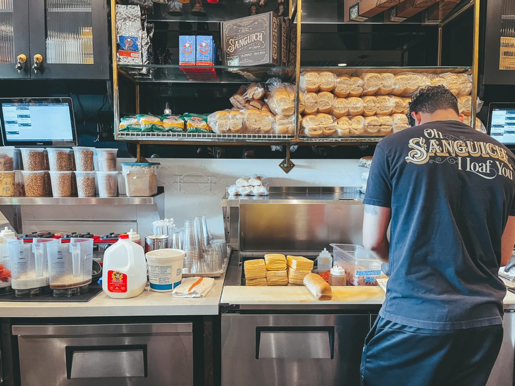 An employee preparing sandwiches at Sanguich on Calle Ocho