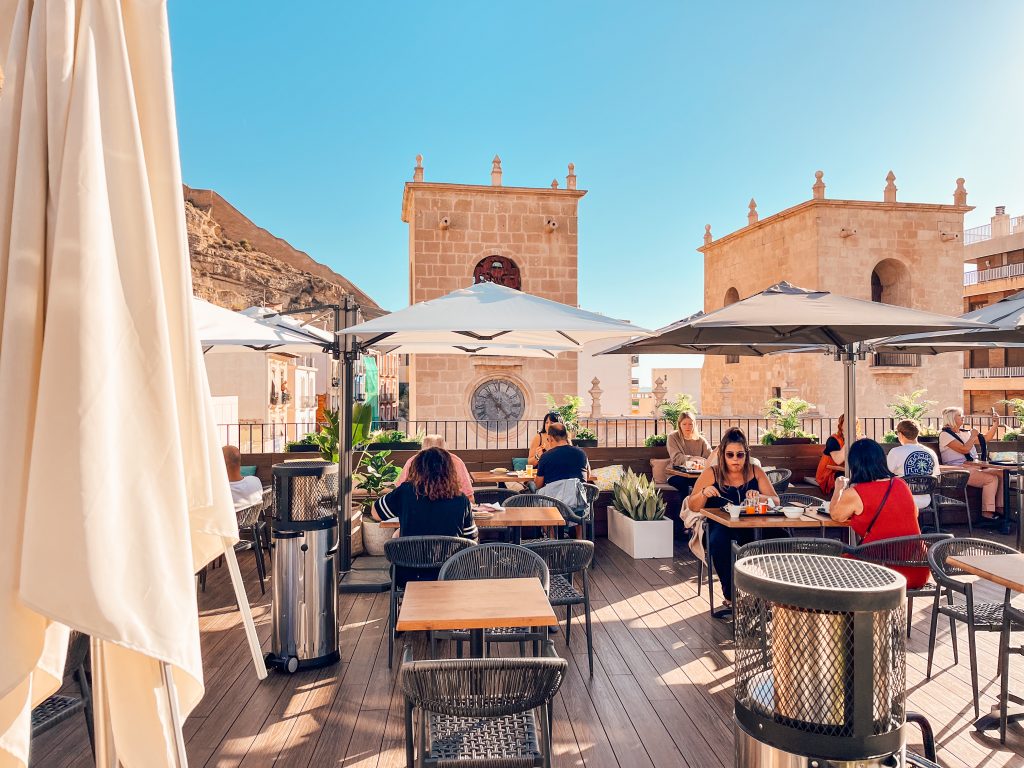 Guests eating breakfast on the sunny rooftop of Hotel La Milagrosa in Alicante