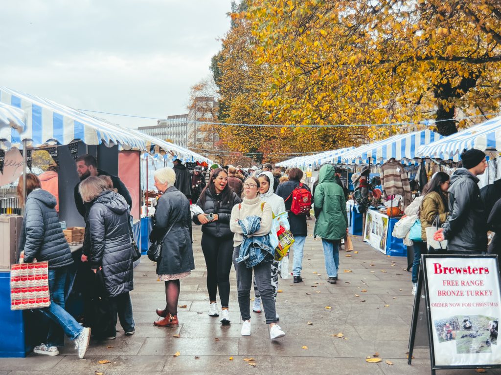 People shopping and walking through the stalls at Edinburgh Farmers Market