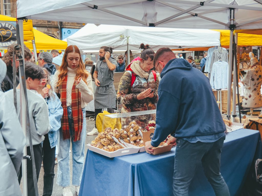 People buying cakes at Grassmarket Market in Edinburgh