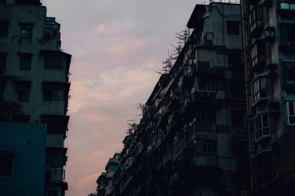 Silhouette of tall, old apartment buildings against a dusky sky with soft pink clouds.