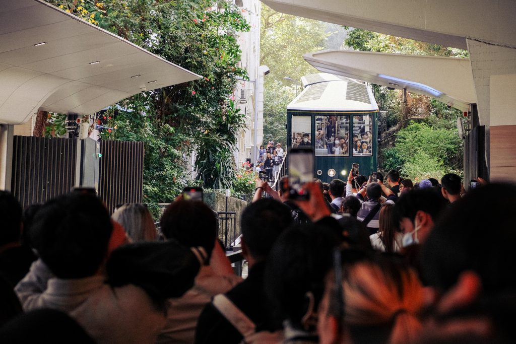 Weekend crowds gather at the platform and take photos of Hong Kong's Peak Tram as it pulls into the station.