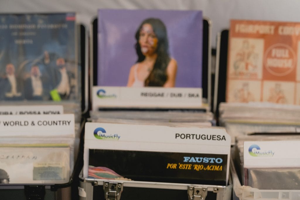 Vinyl records in bins sorted by genre, including Portuguesa, with album covers visible in front.