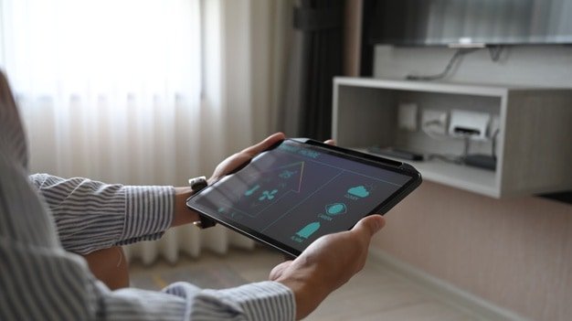 le-mani-con-immagini-ritagliate-utilizzano-un-tablet-con-applicazioni-controllate-dai-dispositivi-domestici-sullo-schermo_35674-2905
