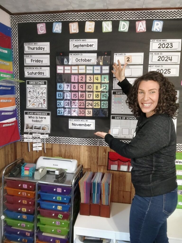 Jenn Adams, Pennsylvania homeschool evaluator, by a classroom calendar