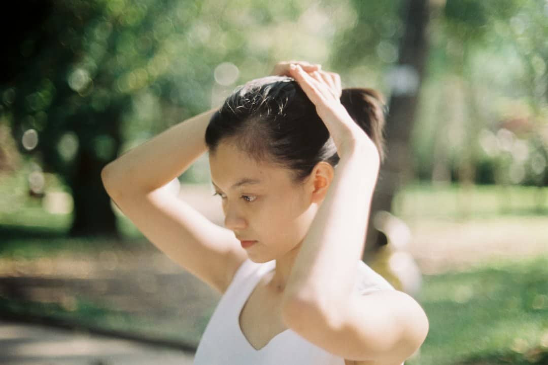 東方女性在公園運動前整理頭髮