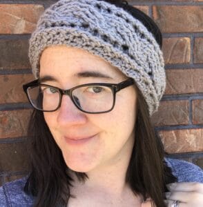 Portrait of a woman wearing glasses and a knitted headband.