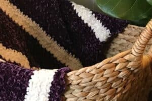 Juniper and Oakes woven basket with cozy, plush blanket in purple, white, and beige tones.