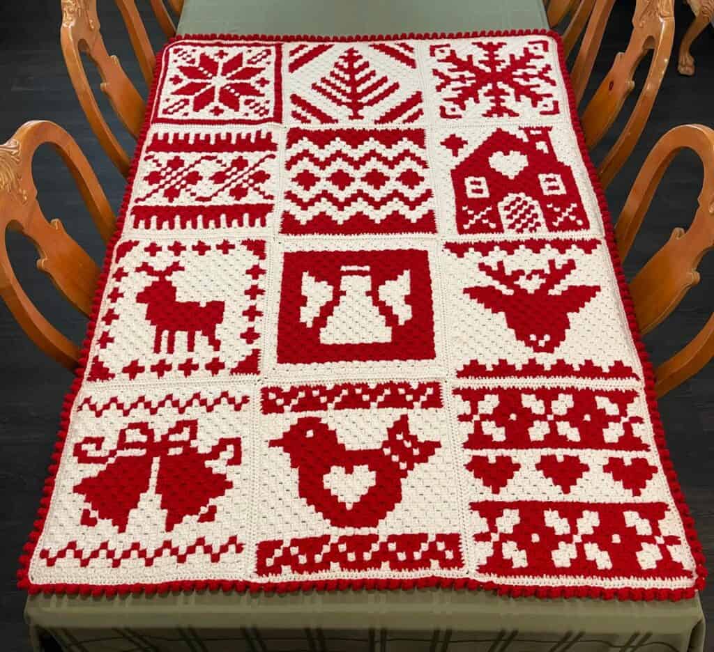 Hand-crocheted Nordic winter Afghan with festive red and white Christmas patterns.
