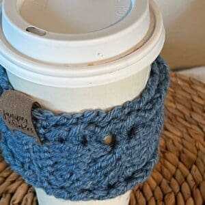 Coffee cup with a knitted sleeve, perfect for warm beverages and cozy mornings.