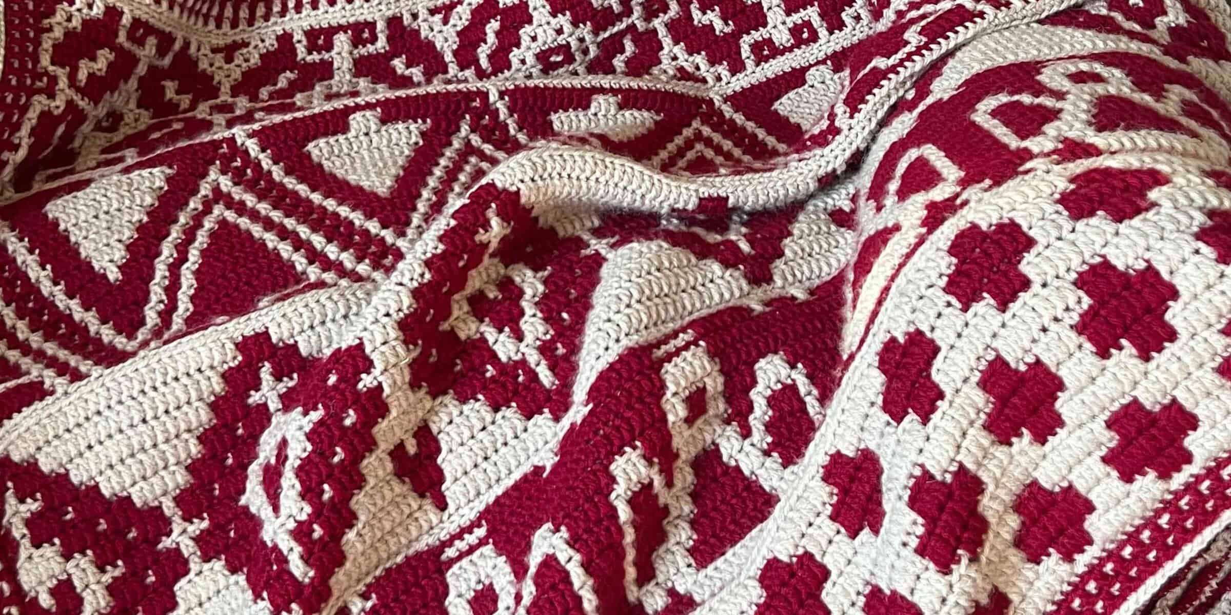 Close-up of intricate red and white woven textile from Juniper and Oakes.