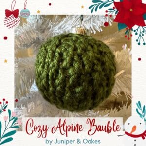Alpine green knitted bauble hanging on a Christmas tree.