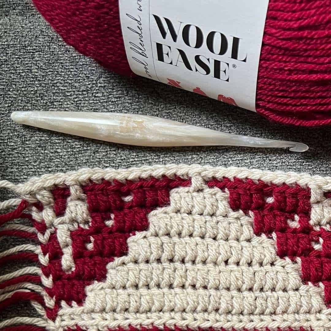 Close-up of crochet overlay mosaic pattern with cream and red yarns.