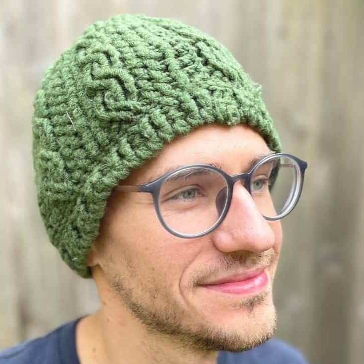 Green cabled granny crochet hat with textured pattern and embroidered details.
