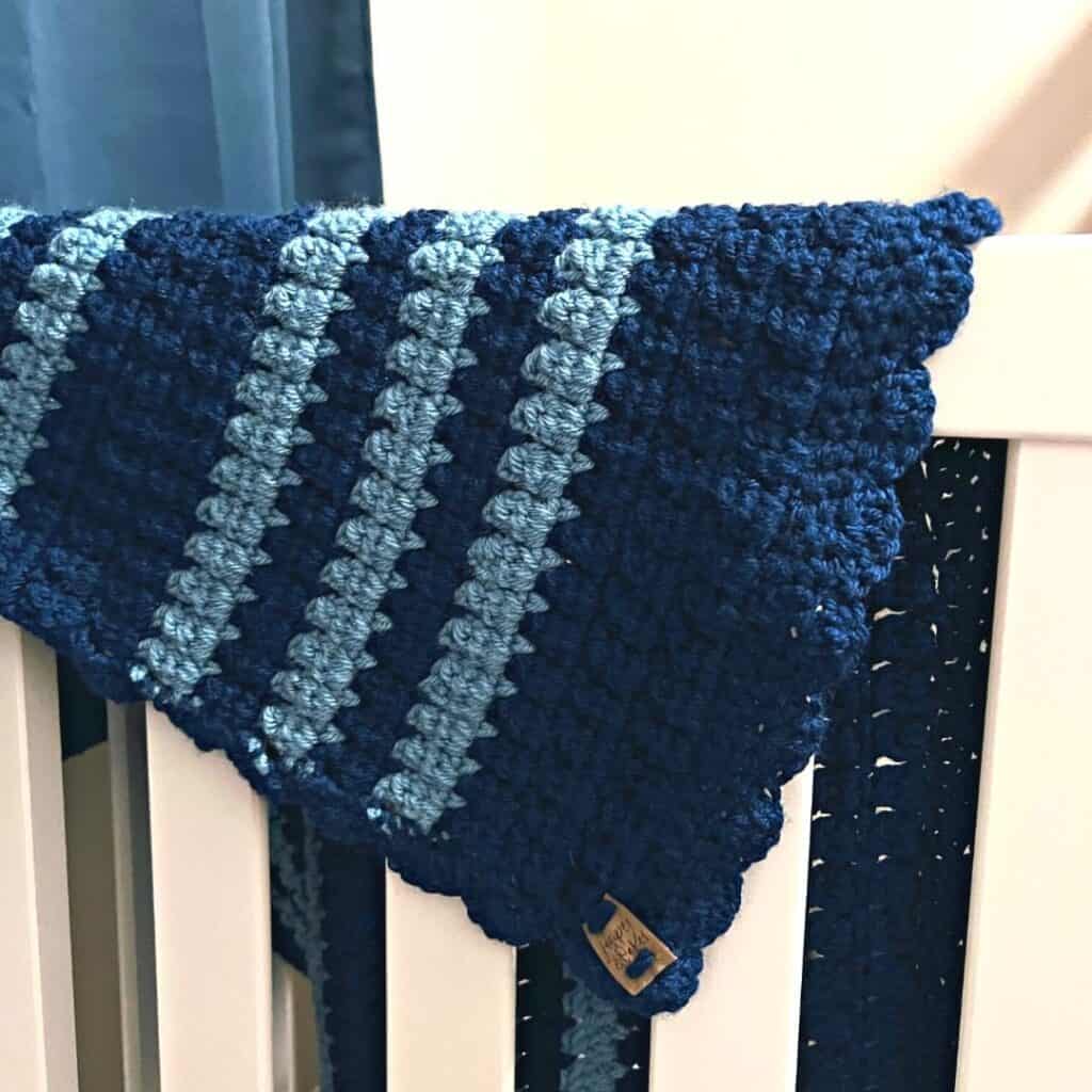 Crochet cluster stitch sample in blue yarn for sampler poncho project.