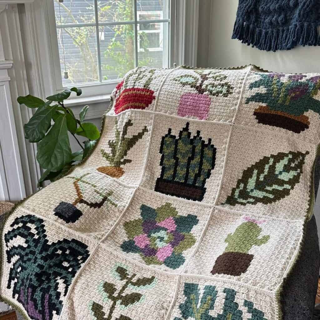 Crochet pillow with daffodil and greenery motifs, inspired by the Daffodil C2C Pillow Crochet Patter.