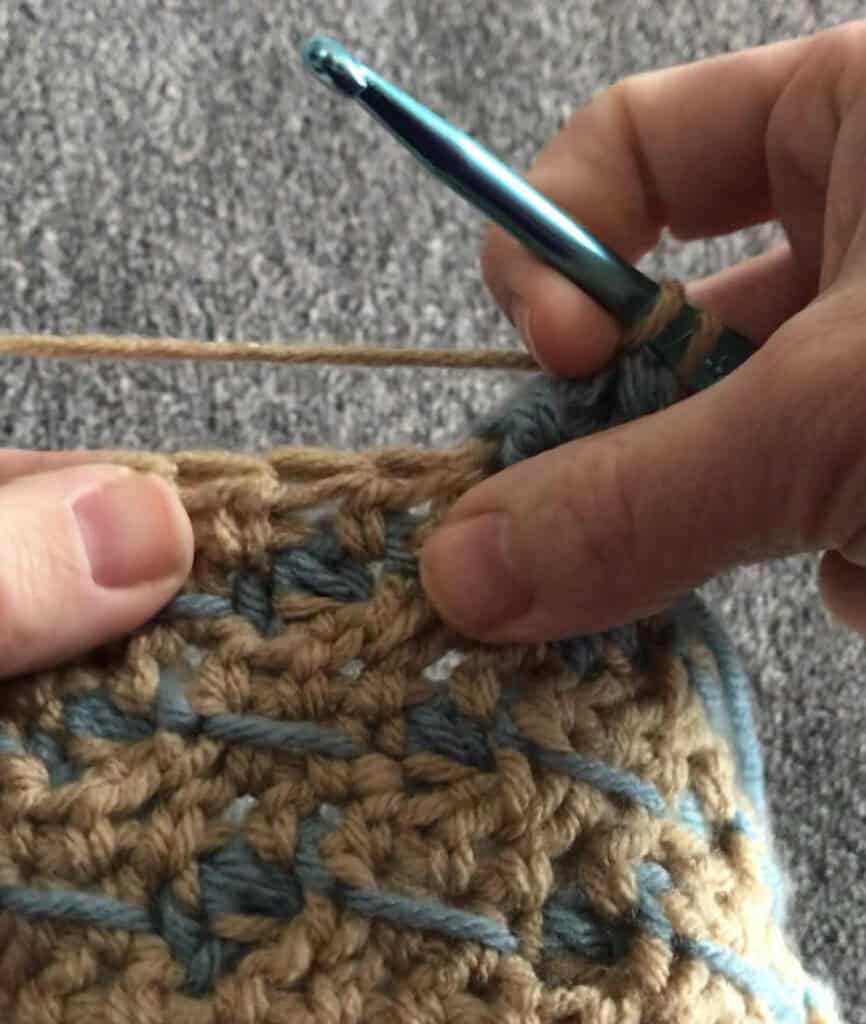 Crochet hook and yarn in use, focusing on handmade crochet project.