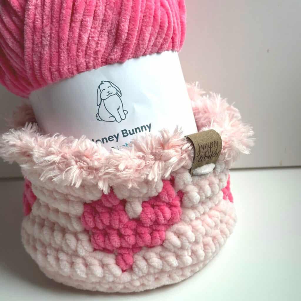 Yarn cozy with pink and white textures, designed for a honey bunny-themed project.