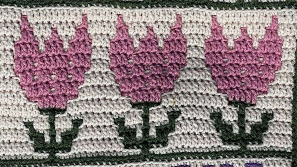 Handwoven floral rug with pink tulips and green leaves, home decor piece.