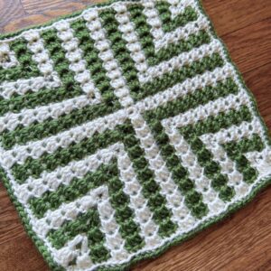 Hand-crocheted Christmas pattern with green and white yarns.