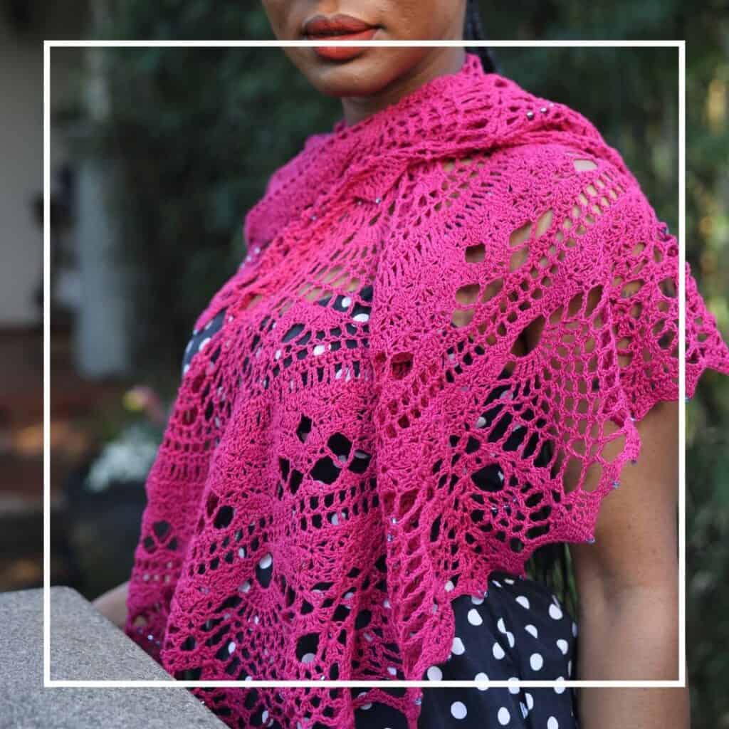 Pink crochet shawl with intricate lace patterns.
