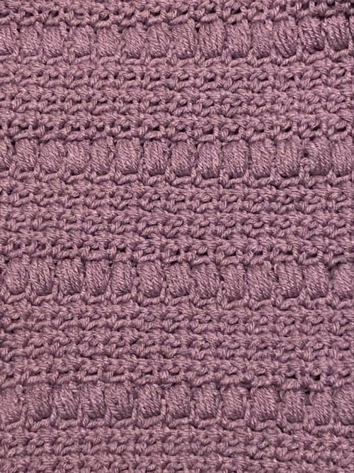 Handwoven textured fabric in soft mauve color.