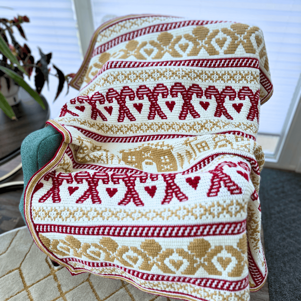 Festive mosaic crochet gingerbread blanket with red and gold patterns.