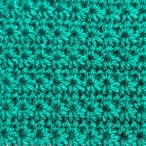 Close-up of turquoise crochet shell stitch pattern for knitting tutorials.