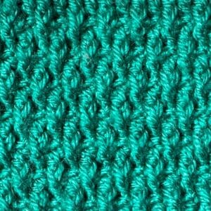 Close-up of textured turquoise Alpine crochet stitch pattern.