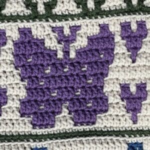 Detailed crochet sunflower mosaic design in purple and white.
