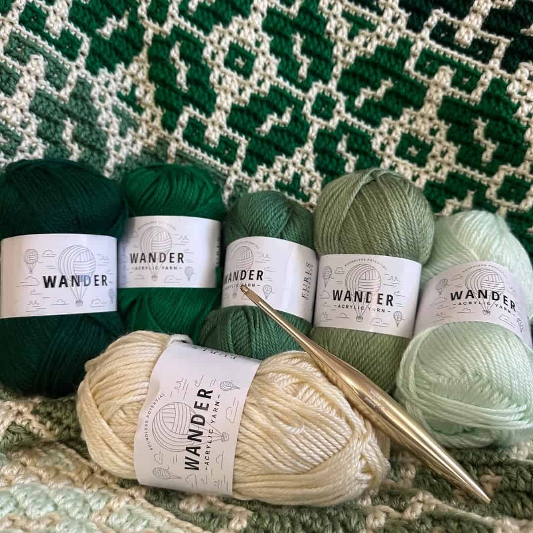 Wander acrylic yarns in green and cream for crochet projects.